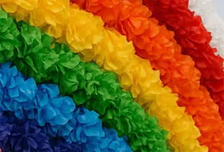 Bright rainbow tissue paper garlands in layered bands of vibrant colors