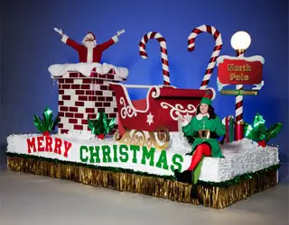 Christmas parade float featuring Santa's sleigh, candy canes, North Pole sign and festive holiday décor