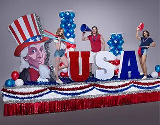 Patriotic parade float with Uncle Sam graphic, USA lettering, balloons and red, white and blue decorations
