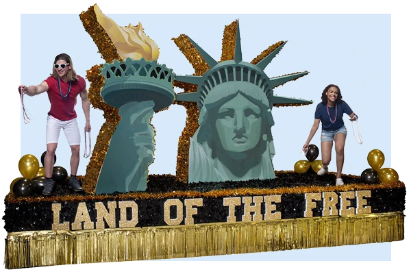 Patriotic parade float with red white and blue stars, American flags, and Freedom Land of the Free lettering with festive fringe.