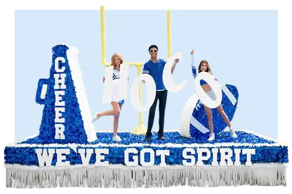 Blue and white school spirit float featuring cheer megaphones, large "HoCo" letters, a football goalpost, and a banner reading "WE'VE GOT SPIRIT."