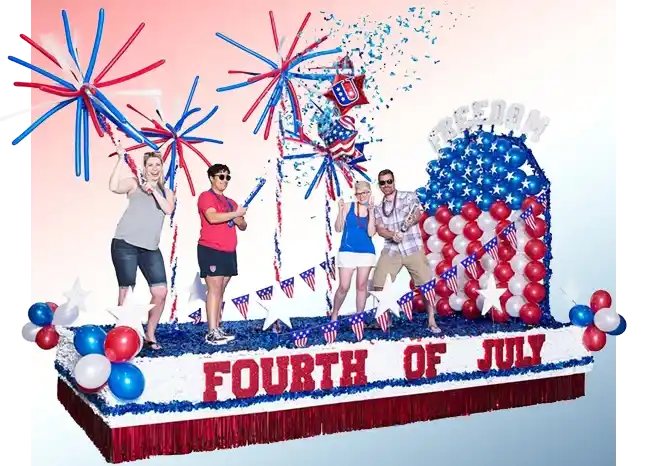 Fourth of July parade float decorated in red, white, and blue, featuring people standing among balloon fireworks, patriotic bunting, and a large balloon number four, with Fourth of July text across the front.